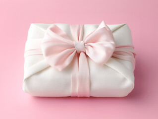 명절 선물 보자기 Bojagi present wrapped with a white fabric wrapping cloth, pink bow, for Korean Thanksgiving Day, the Asian Mid Autumn festival 
