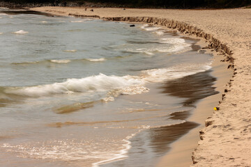 The incoming waves of Lake Michigan are actively eroding the beach shoreline in early October at...