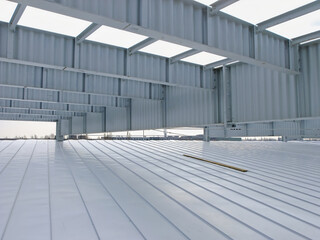 Metal framework of an industrial building under construction, showing the roof structure.