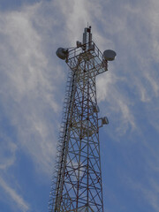 A tall communication tower against a blue sky with scattered clouds, highlighting modern technology.