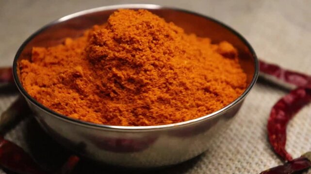 Dry chili spice and red pepper powder on bowl close up 4k video. Filmed on camera, 4k, 1000 fps footage. 