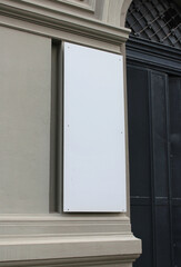 Fototapeta premium Large white billboard banner on an office or storefront mockup. Blank white office or shop sign mock up template.