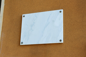 Blank marble sign on a wall of a building mockup. Empty marble signage of a restaurant or shop sign mock up template.