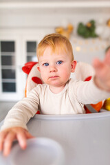 an emotional toddler sitting in a highchair.leery eye