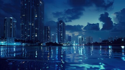 Obraz premium Nighttime view of a city skyline reflected on water.