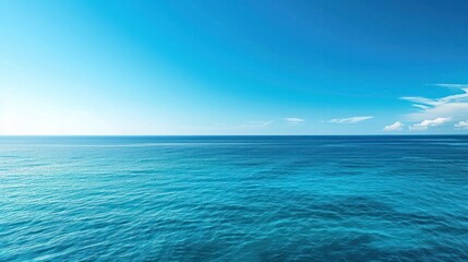 Obraz premium A serene and expansive view of the blue sea stretching out to the horizon, where the azure waters meet the clear blue sky in a seamless union of color and light