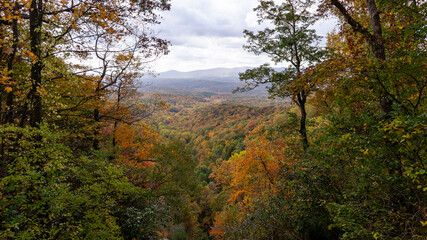 A view of the southern Appalachian mountains in peak fall foliage framed by fall trees....
