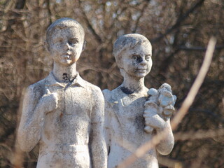 Old sculptures of children in a children's camp. Abandoned place.