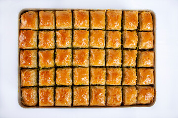 Top view of baked pistachio or walnut baklava on a tray isolated on white background.