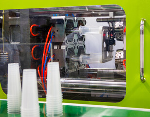 Plastic cups from plastic injection molding press machine. Industrial manufacturing	