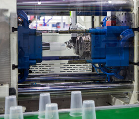Plastic cups from plastic injection molding press machine. Industrial manufacturing	
