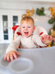 an emotional toddler sitting in a highchair.leery eye