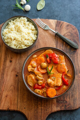 Fried pork loin in tomato sauce with mushrooms, red peppers and carrots served with couscous