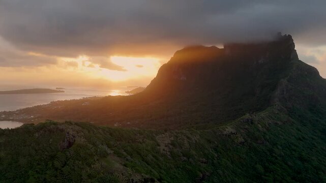 Sunset behind Mount Otemanu on Bora Bora island. The mountain top is covered with low clouds. 