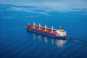 Bulk cargo carrier ship underway in calm sea. Dry cargo vessel merchant ship to transport bulk...