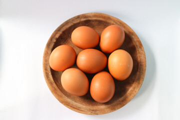 Eggs on a wooden plate on a white background. Food photography.