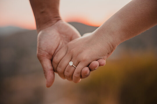 Engaged Couple Holding Hands with Engagement Ring