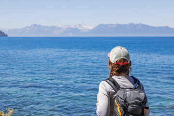 Woman hiker Observing Scenic View of the lake Tahoe With Mountains on the background