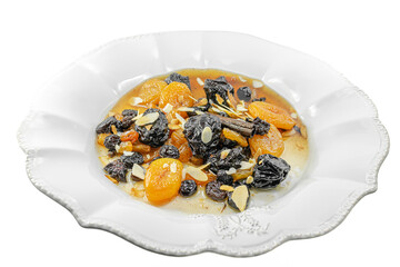 Traditional Algerian sweet dish beautiful white plate with raisins, black and orange dried apricots or prunes, a cinnamon stick, flaked almonds in sauce. Isolated in a white transparent background. 