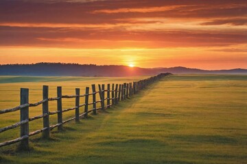 Fototapeta premium Fence Line at Sunset: A landscape showing a row of rustic fence posts and rails silhouetted against a vibrant sunset.