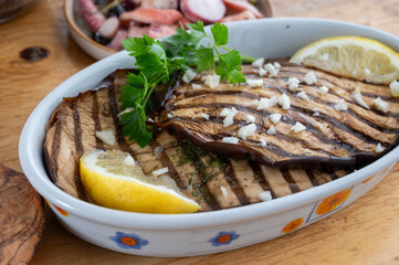 Italian style starter served in restaurant, grilled eggplant with garlic, olive oil and fresh parsley