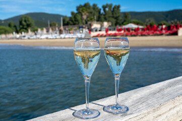 Summer time in Provence, two glasses of cold champagne cremant sparkling wine on famous Pampelonne sandy beach near Saint-Tropez in sunny day, Var department, France, beach club party