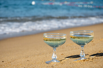 Summer time on French Riviera, two coupe glasses of champagne cremant sparkling wine on Pampelonne sandy beach near Saint-Tropez in sunny day, Var, vacation in France