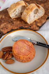 Rond des Vignes washed-rind cheese with.ivory-orange rind, strong nose with aromas, French soft cheese with orange rind