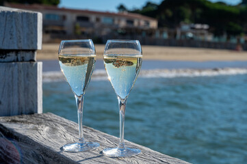 Summer time in Provence, two glasses of cold champagne cremant sparkling wine on famous Pampelonne sandy beach near Saint-Tropez in sunny day, Var department, France, beach club party