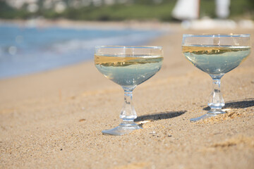 Summer time on French Riviera, two coupe glasses of champagne cremant sparkling wine on Pampelonne sandy beach near Saint-Tropez in sunny day, Var, vacation in France
