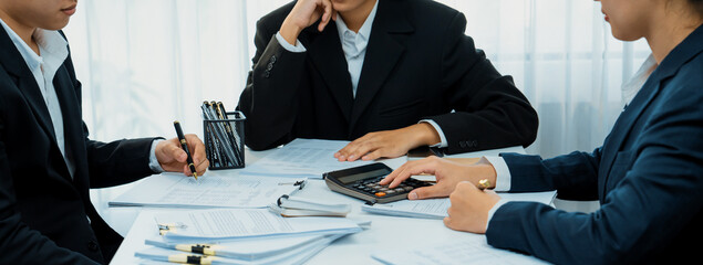 Corporate accountant team use calculator to calculate and maximize tax refunds and improve financial performance based on financial data report. Modern business accounting in panorama. Shrewd