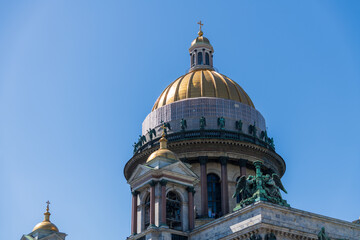 Close-up view of golden dome of Russian Orthodox Saint Isaac's Cathedral (or Isaakievskiy Sobor) against clear blue sky in Saint Petersburg, Russia. Russian culture and arhitecture theme.