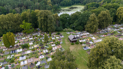 Drone photography of a graveyard surrounded by forest during summer cloudy day