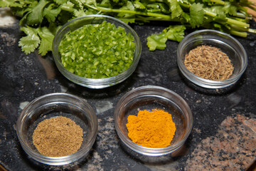 The ingredients used to make a Tandoori Chicken including spices on a wooden kitchen table