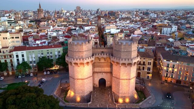 drone view of Valencia Torres de Serranos with evening illumination, sunset aerial view of Valencia old town in Spain, tourism in Southern Europe, travel in Spain