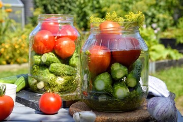 Preparation of pickled cucumbers and tomatoes with herbs, garlic and dill. Home canning, fermented vegetables.