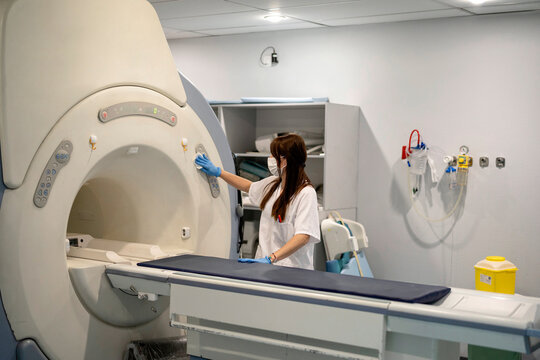 Woman disinfecting CT machine in clinic
