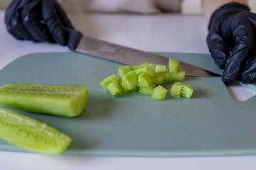 Cutting the cucumber. Peeled cucumber. Small slices of cucumber