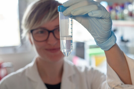 female scientist holding test tube in scientific lab, medical research