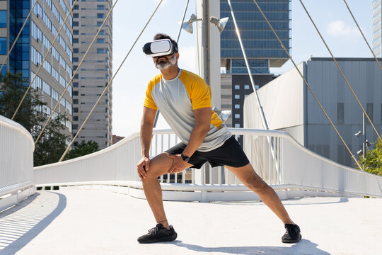 Indian man in VR headset exercising in urban setting