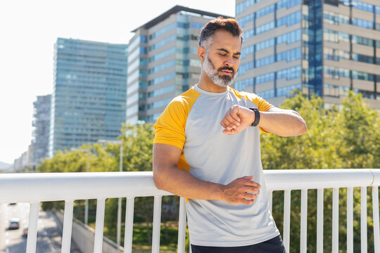 Indian man checking time during summer sports training
