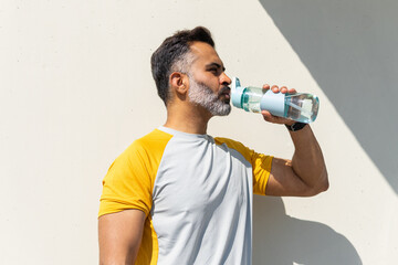 Indian man hydrating during summer workout