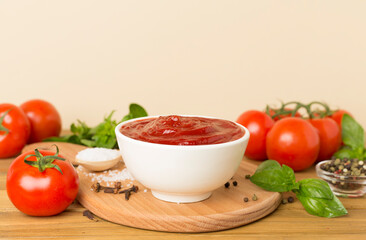 Delicious ketchup with spices and tomatoes on wooden table