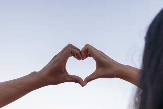 Valentine couples use their hands to make heart symbols to symbolize friendship and loving-kindness towards their lover and friends because heart symbols signify love, friendship and kindness.