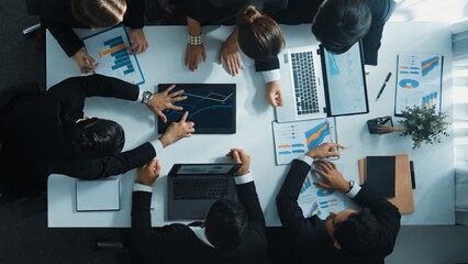 Top view of smart business people brainstorm marketing idea at meeting table while compare stock market investment data between laptop and tablet. Business team planning financial plan. Directorate.