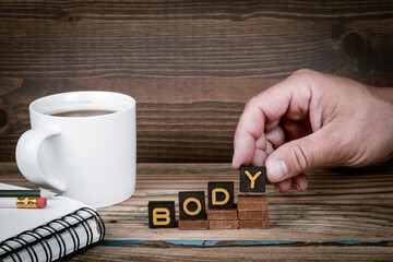 BODY. Old letter tiles on wooden steps, development concept