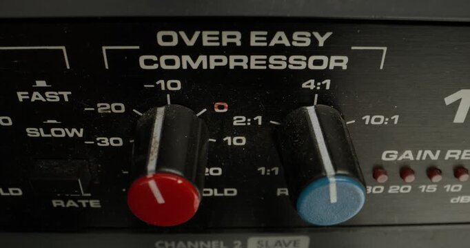 A man adjusts a vocal compressor in a recording studio. Close-up of his hand, an unrecognizable person