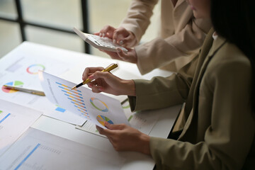 Obraz premium Business Professionals Analyzing Financial Data and Charts in a Modern Office Setting