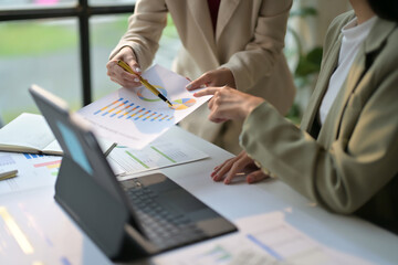 Business Meeting with Colleagues Analyzing Financial Charts and Graphs in a Modern Office Setting