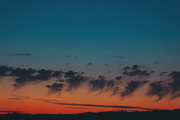 Beautiful sunset sky background with clouds. Golden sunset with contrasting blue sky. dramatic sunset with clouds over the city rooftops. 